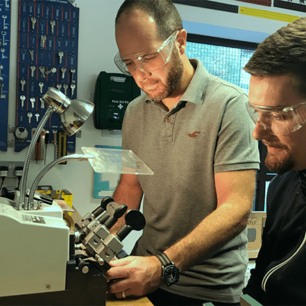 locksmith trainer teaching locksmith student how to cut keys